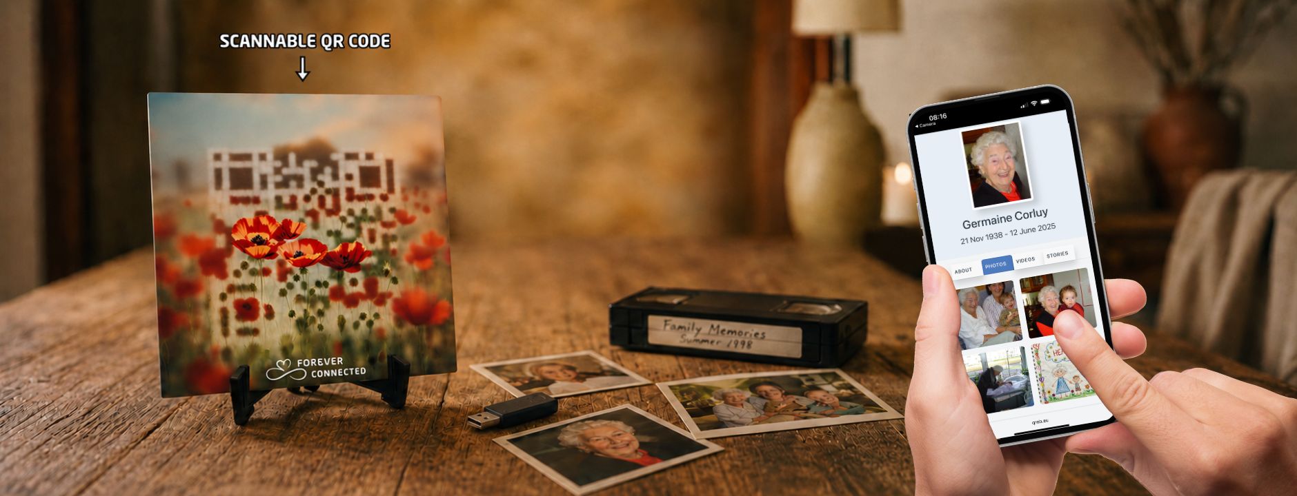 A  ceramic tile resting on a black stand, featuring red poppies with an embedded QR code that leads to a  digital memorial website. Scattered memories on a USB stick, a VHS video tape and printed photos