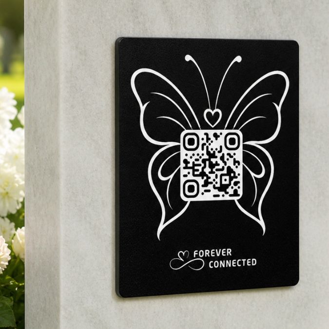 Forever Connected black plaque with  butterfly QR remembrance plaque on a light stone headstone, connecting visitors to an online tribute page with memories of a loved one