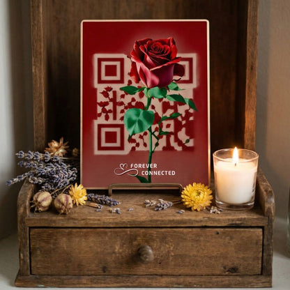 Decorative setup with a red rose card, candle, and flowers on a wooden surface.