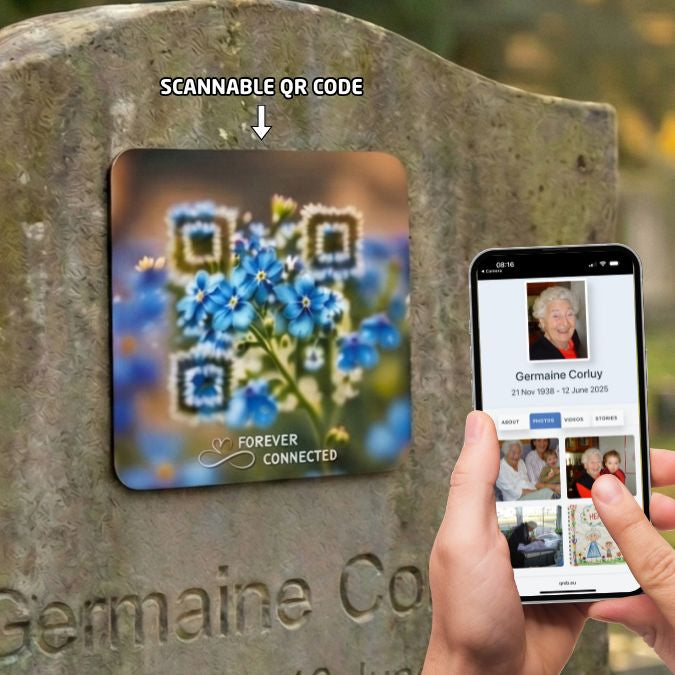 A square memorial plaque featuring a QR code artfully integrated into a blue forget-me-not floral design with the text "Forever Connected" at the bottom. The QR Plaque is attached to a stone headstone, with a hand in the foreground holding a smartphone displaying the deceased's digital profile page.